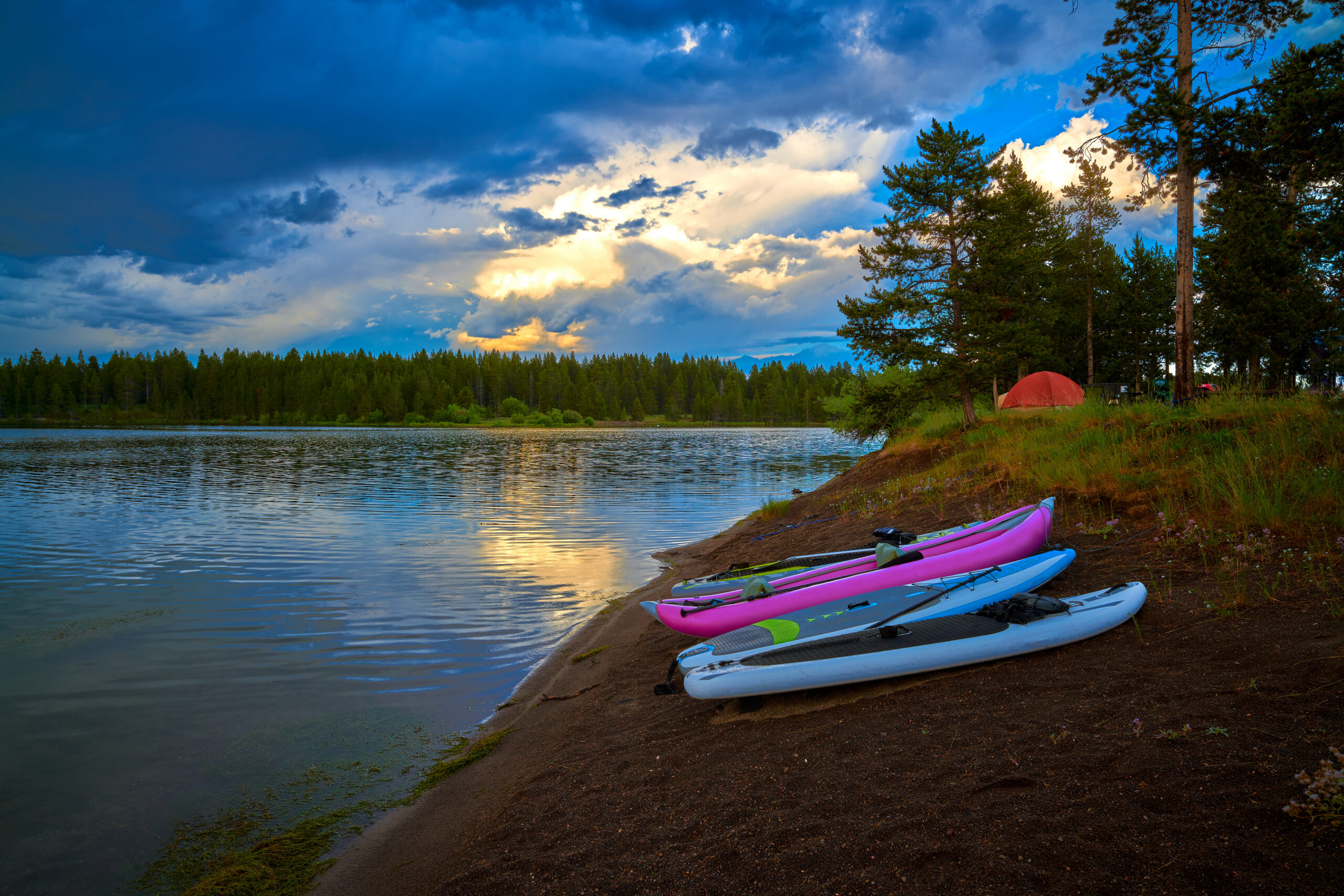 Storm clouds along Hebgen Lake with paddleboard and kayaks.